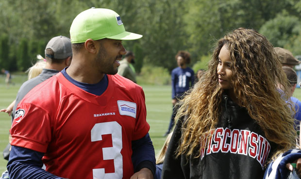 Seattle Seahawks quarterback Russell Wilson, left, walks with his wife, pop singer Ciara, following...