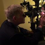 Don O'Neill sits perfectly still while the doctor pulls stitches from his left eye. (Josh Kerns, KIRO Radio)