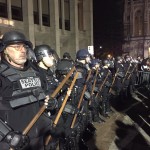Seattle police stand outside Kane Hall on UW campus Friday night  while Milo Yiannopoulos was inside. (Josh Kerns, KIRO Radio)