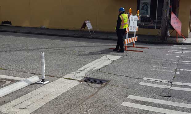 An off-duty officer stands next to a "road closed" sign in Ballard. (File, MyNorthwest)...