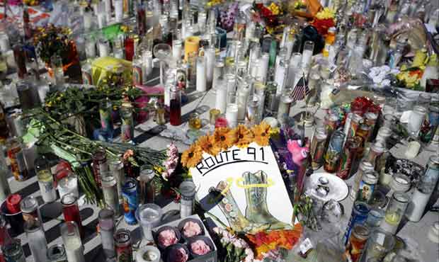 Flowers and candles are left at a makeshift memorial site on Las Vegas Boulevard on Tuesday, Oct. 3...