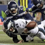    Philadelphia Eagles quarterback Carson Wentz (11) fumbles the ball near the goal line and into the end zone as Seattle Seahawks' Earl Thomas (29) and Sheldon Richardson (91) move in during the second half of an NFL football game, Sunday, Dec. 3, 2017, in Seattle. (AP Photo/John Froschauer)