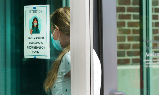 PROVO, UT - AUGUST 13: With a mask sign on the door a teacher walks into Freedom Preparatory Academ...
