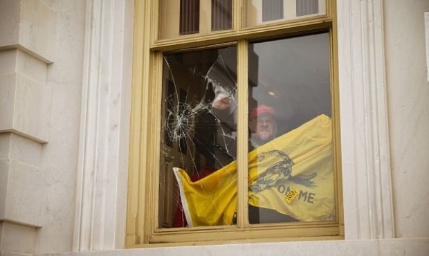 WASHINGTON, DC - JANUARY 06: A member of a pro-Trump mob shatters a window with his fist from insid...