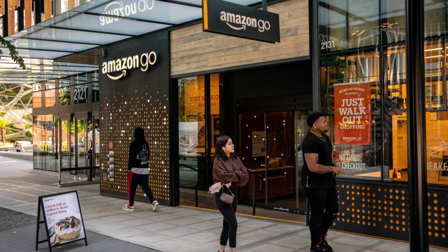 People walk by an Amazon Go store at the Amazon.com Inc. headquarters on May 20, 2021 in Seattle, W...