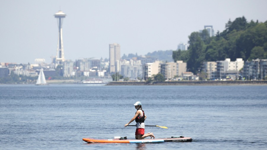 A paddle boarder is pictured at Alki Beach as excessive heat warnings remain in effect a day after ...