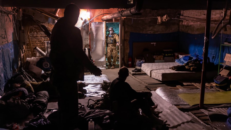 Ukrainian Territorial Defense soldiers prepare to go out from their frontline encampment on May 22,...
