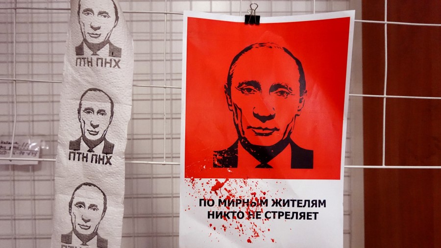 A poster and toilet paper with the likeness of Russian President Vladimir Putin hang on the wall at...