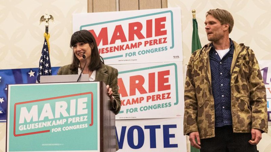 Marie Gluesenkamp Perez, left, speaks to a crowd of supporters while her husband Dean Gluesenkamp l...