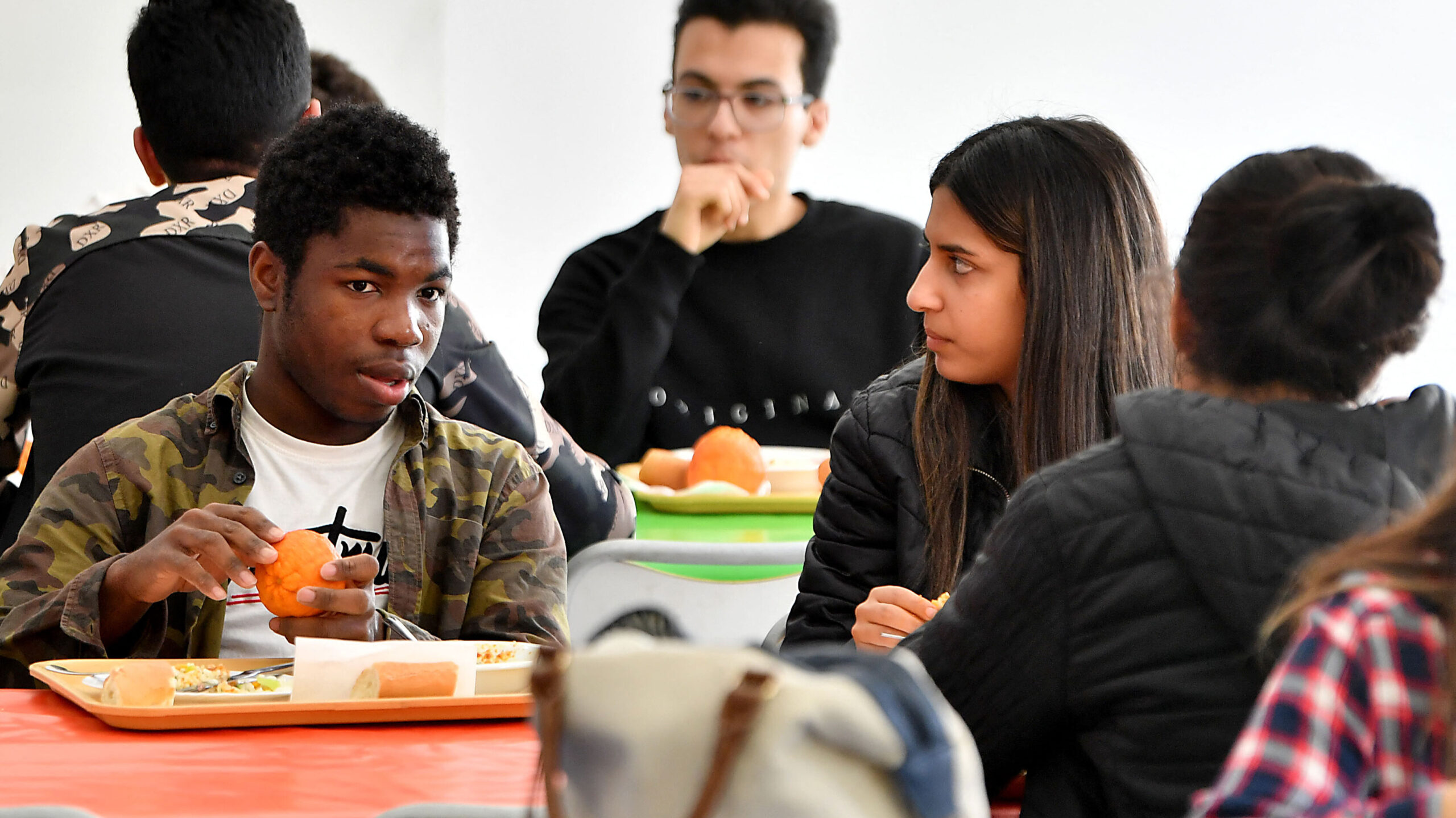 students in lunchroom eat...