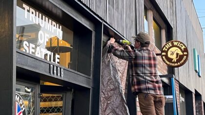 Seattle storefront worker boards up overnight vandalism damage at The Wick Motorcycles & Coffee in ...