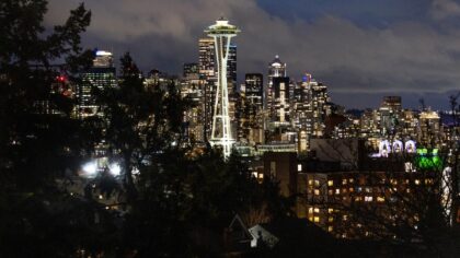 Seattle skyline and Space Needle at night, representing Washington state's high stress ranking in t...