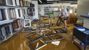Photo: Carrie Owenby looks at her phone as a neighbor with power dropped an extension cord for neighbors who have no power in the aftermath of Hurricane Helene, Monday, Sept. 30, 2024, in Asheville, N.C.
