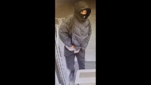 Photo: Masked suspect conceals firearm in his waistband.
