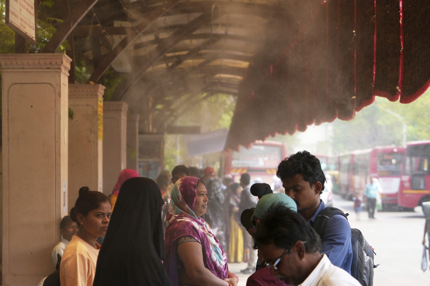People wait for a bus at a cool bus stop in Ahmedabad, India, Wednesday, April 2, 2025. (AP Photo/A...