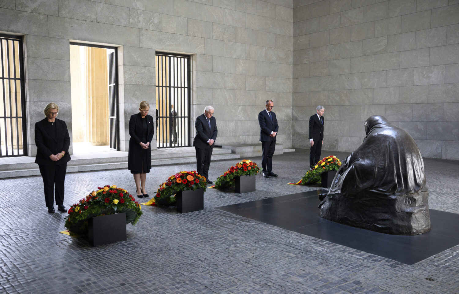 German Federal President Frank-Walter Steinmeier, center, lays a wreath at the Neue Wache, the Fede...