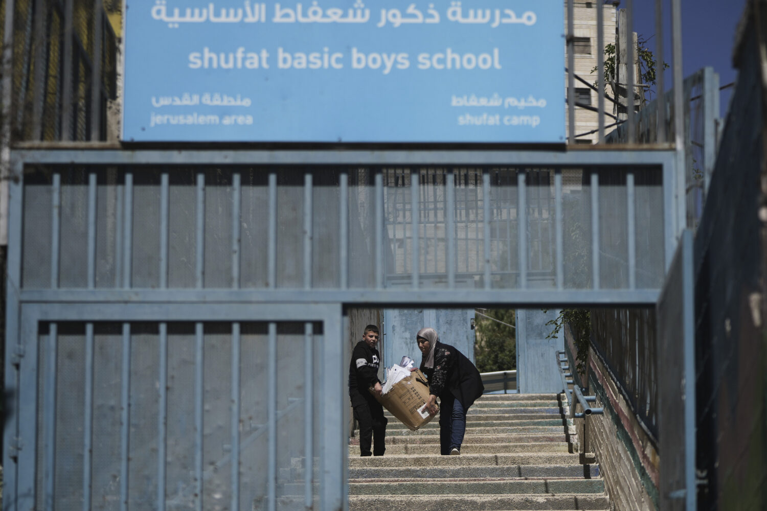 A student and a teacher carry study material at UNRWA Girls School run by the U.N. agency for Pales...