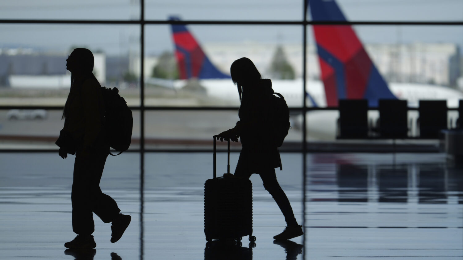 FILE - Travelers walk through Salt Lake City International Airport Friday, May 24, 2024, in Salt La...