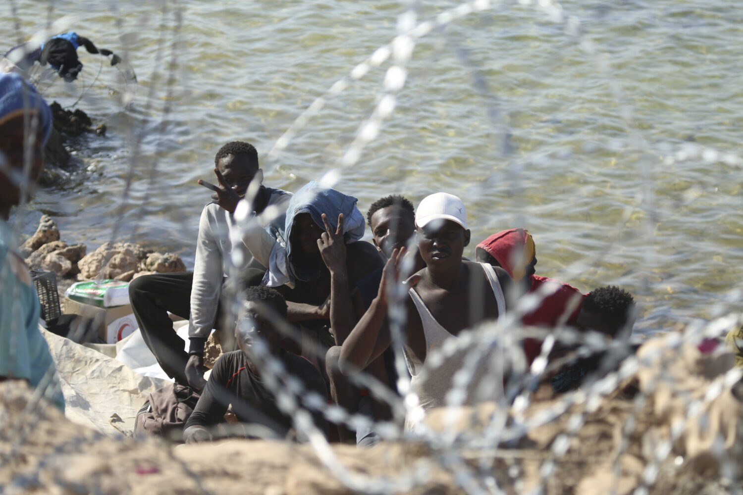 FILE - Migrants gather in an area near the Libyan-Tunisia border, as Libyan security forces and Lib...