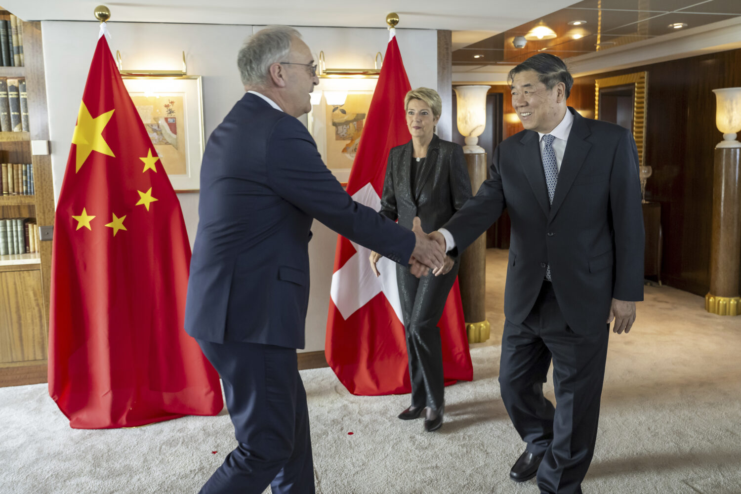 Switzerland's Economy Minister Federal Councillor Guy Parmelin, left, shakes hands with Chinese Vic...