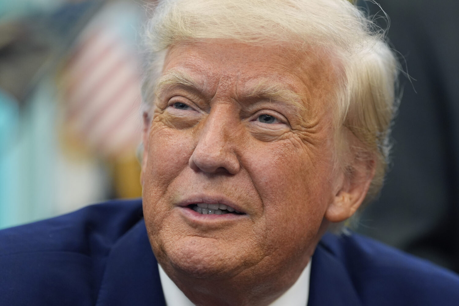 President Donald Trump speaks with reporters as he signs an executive order in the Oval Office of t...