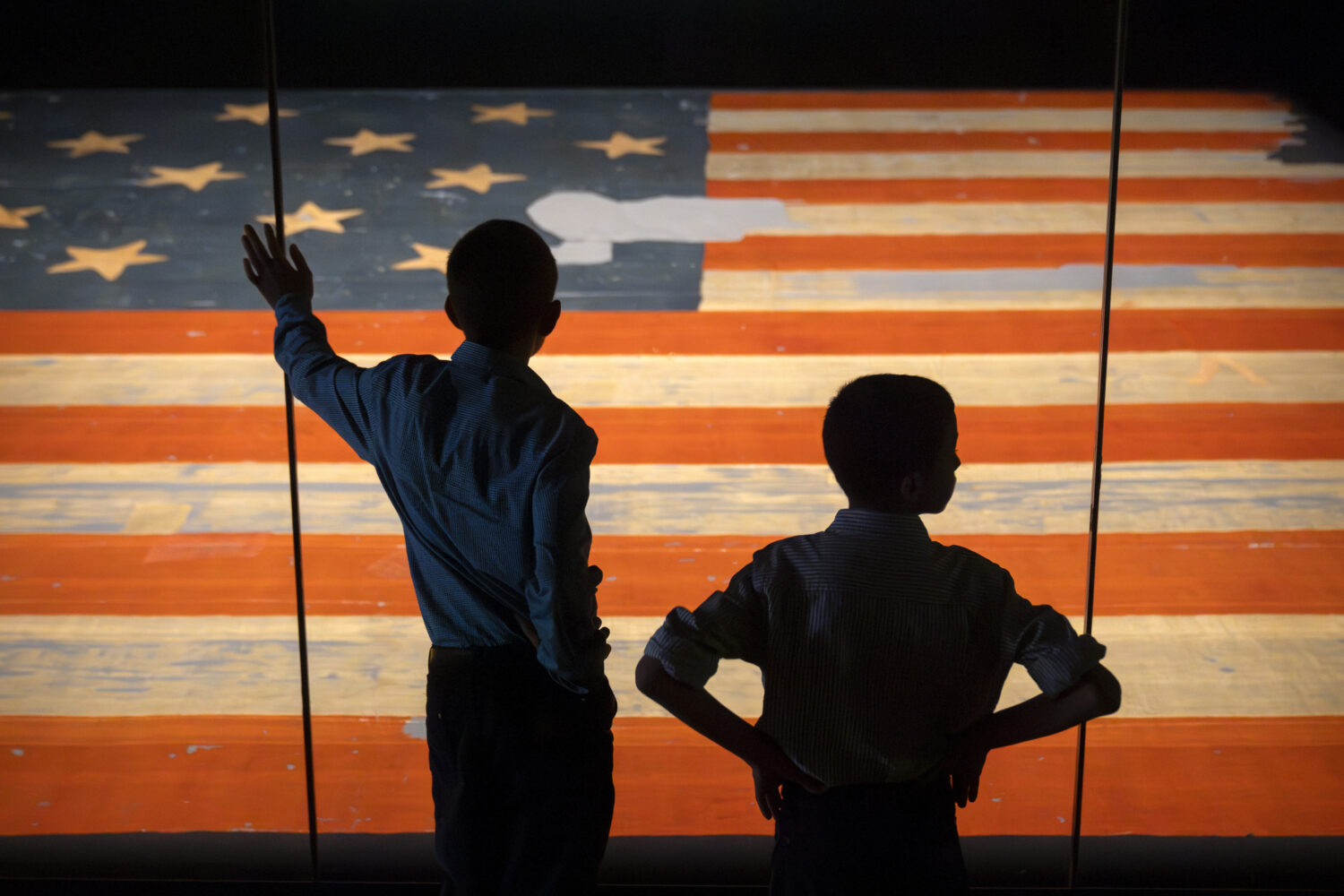 Children look at the Star Spangled Banner, the flag that inspired the lyrics of the American nation...