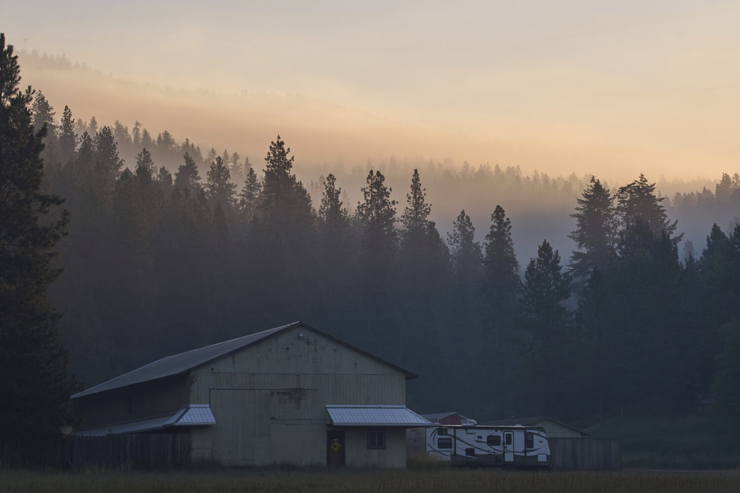 Smoke fills the air the day after a shooter ambushed and killed multiple firefighters responding to...
