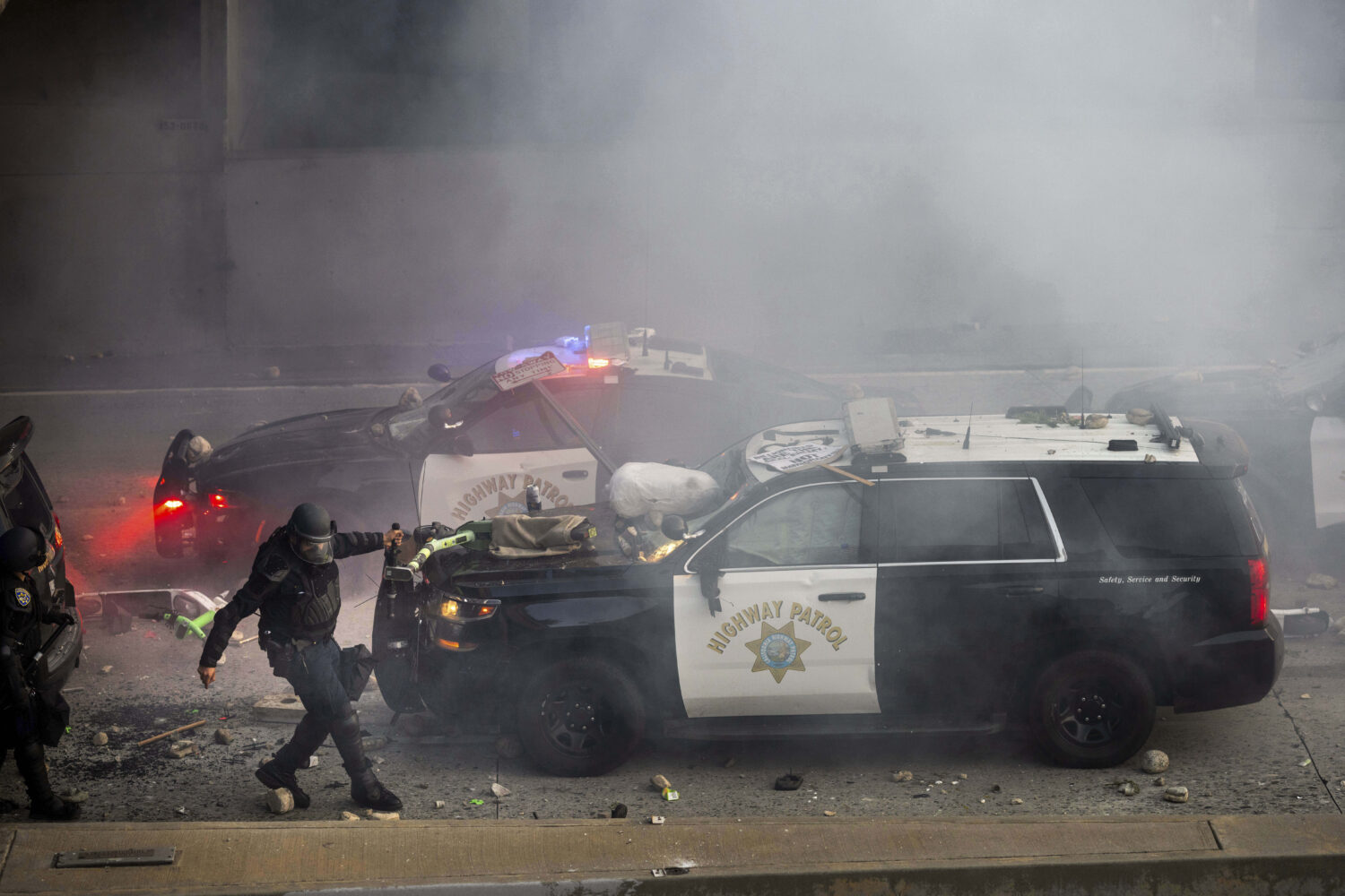 A California Highway Patrol officer pulls an electric scooter off a vehicle on a highway as protest...