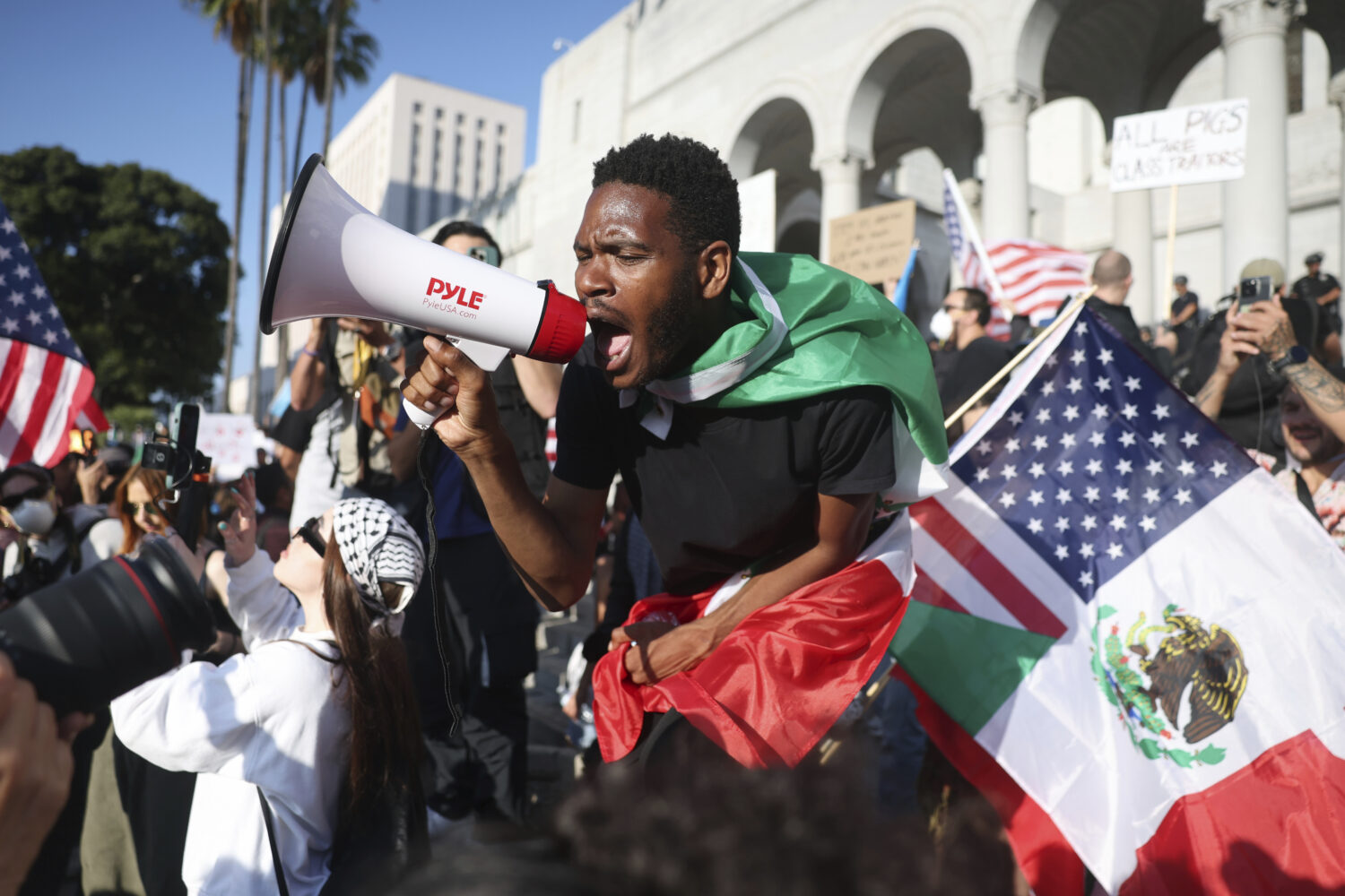 A man shouts into a megaphone outside City Hall during a protest on Wednesday, June 11, 2025, in Lo...