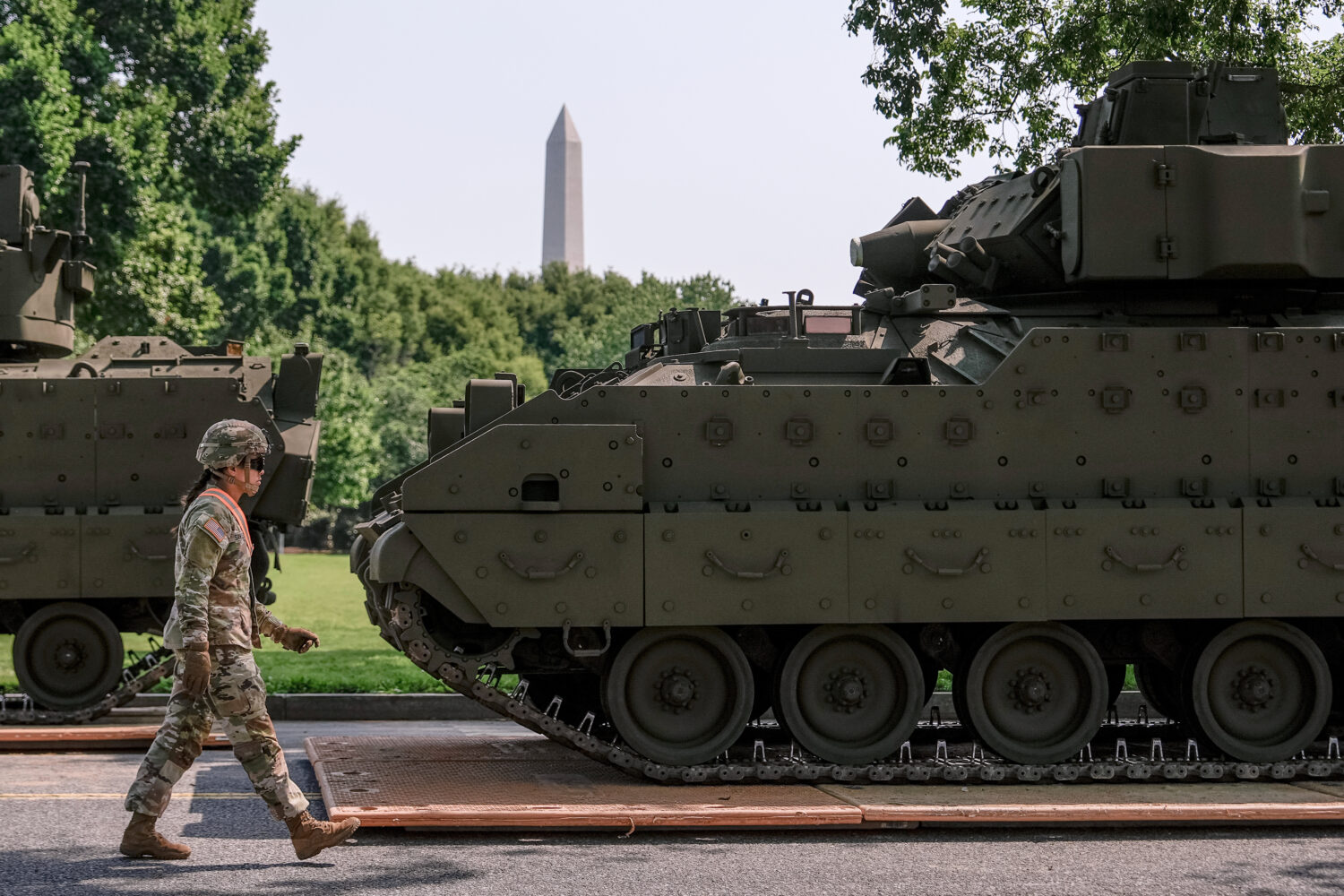 A U.S. Army soldier walks past a Bradley fighting vehicle staged in West Potomac Park ahead of an u...