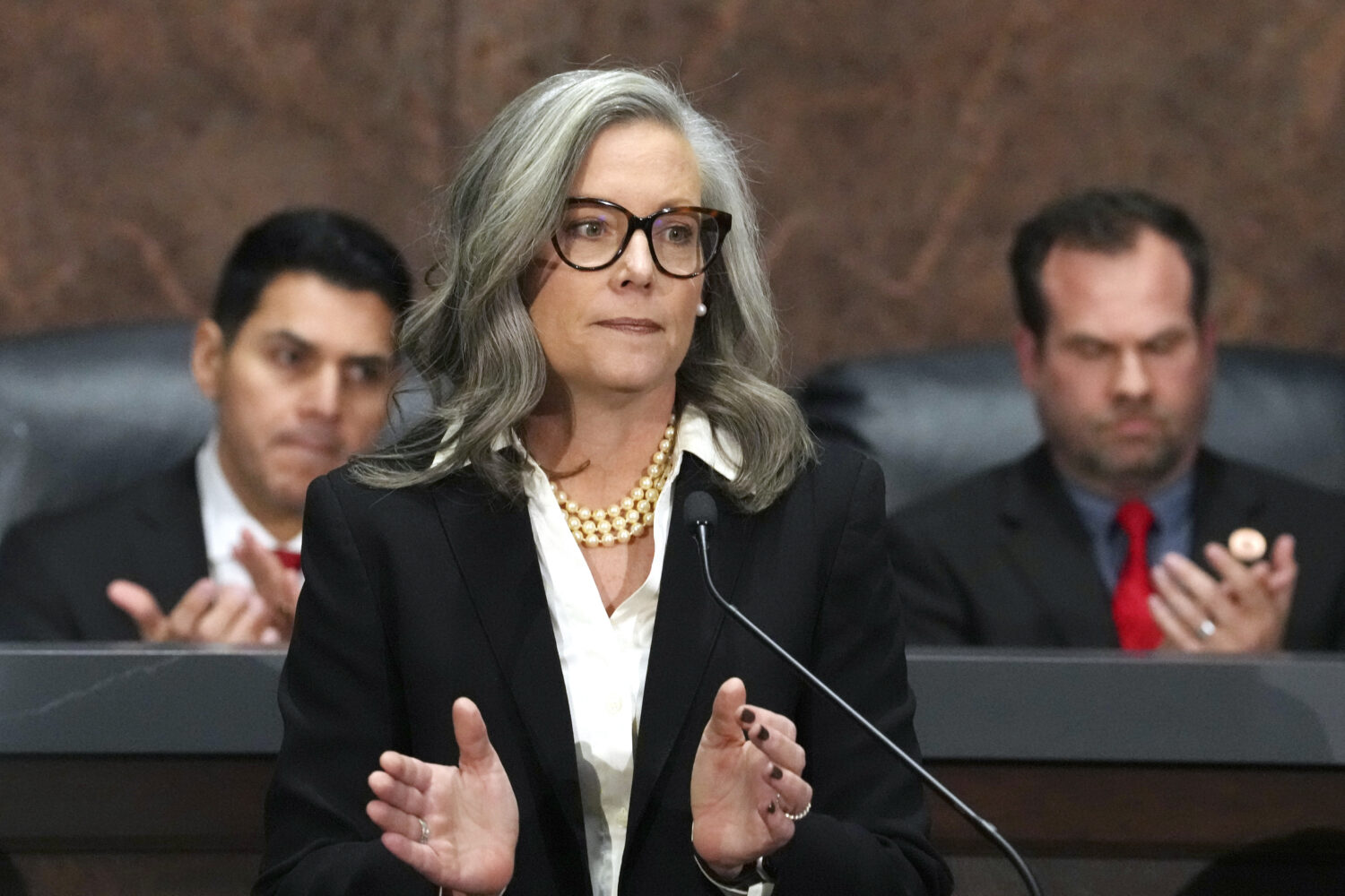 FILE - Arizona Democratic Gov. Katie Hobbs, center, applauds for those affected by the Los Angeles ...
