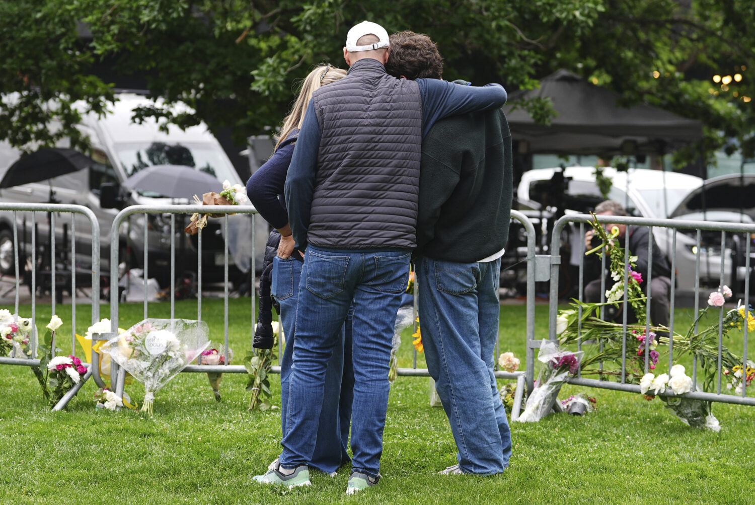 As Jennifer Dechtman, back, looks on, her husband Evan, front left, consoles his son, Isaac, right,...