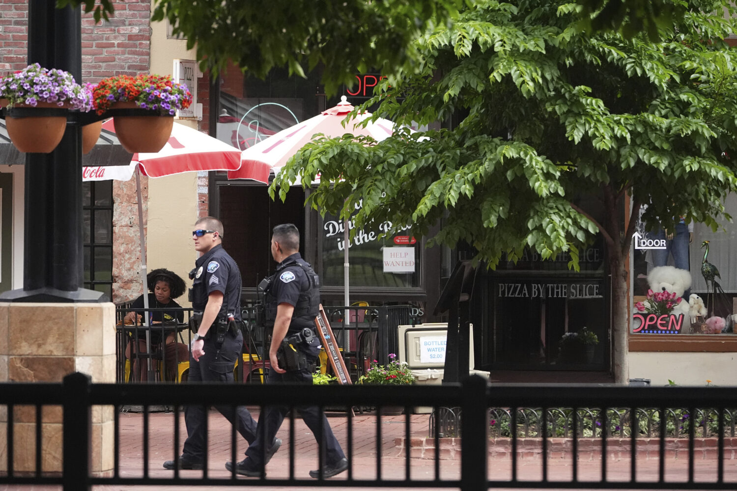FILE - Boulder, Colo., Police Department officers walk the Pearl Street Mall in front of the county...