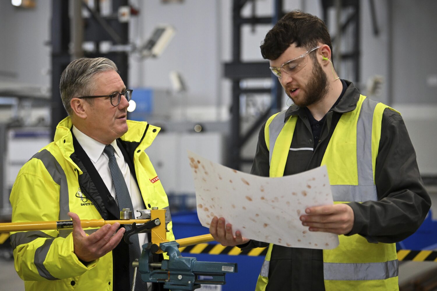 Britain's Prime Minister Keir Starmer, left, speaks to a member of staff during a visit to the BAE ...
