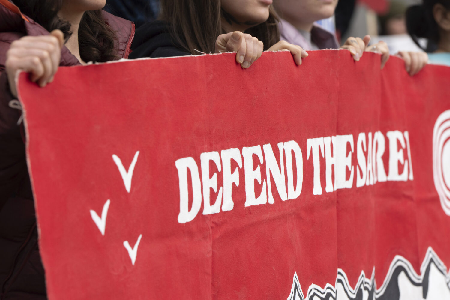 CORRECTS TO ANCHORAGE INSTEAD OF DEADHORSE - People hold a sign during a protest outside the annual...