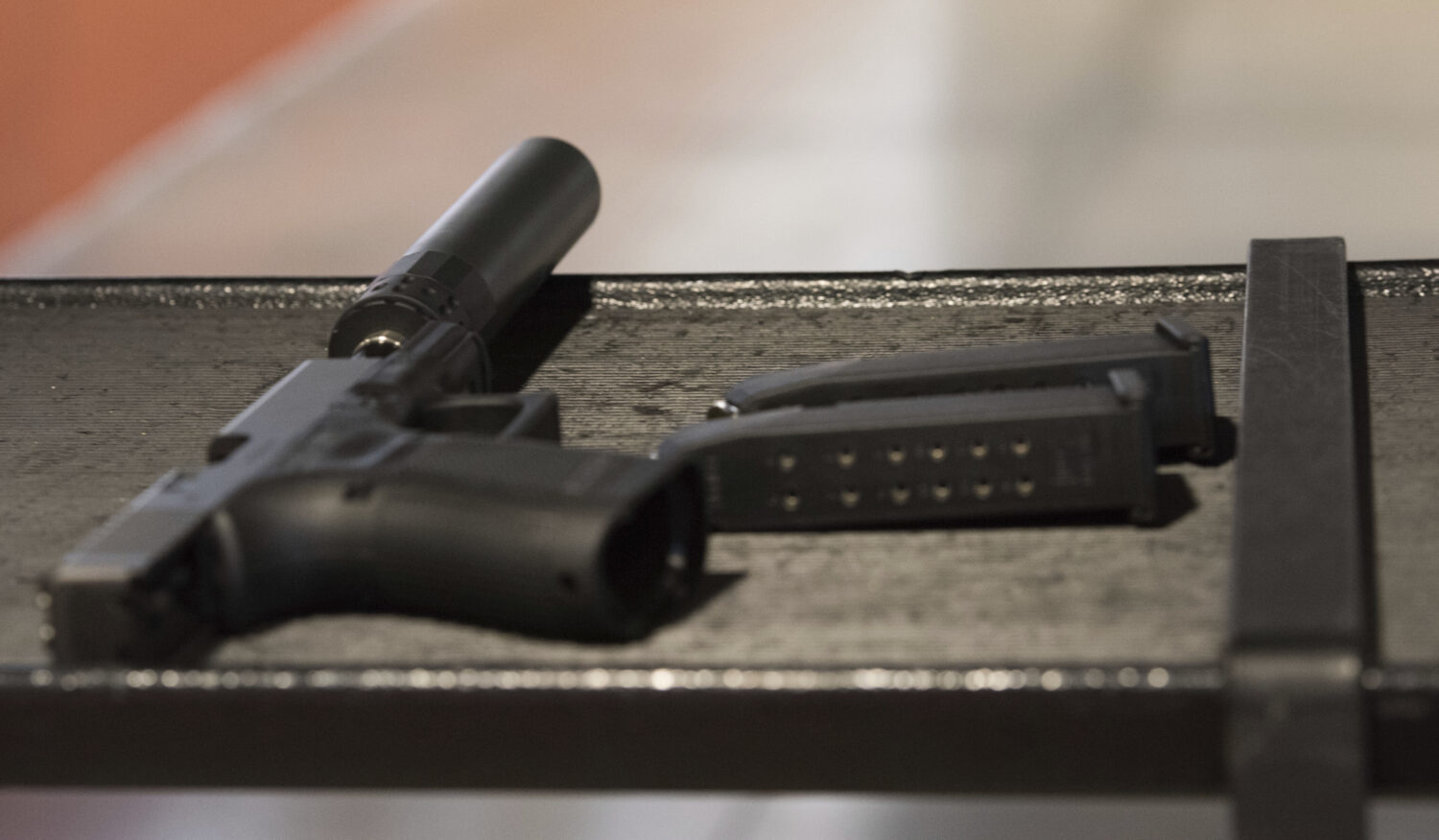 FILE - A handgun with a silencer and two magazines are shown at a gun range in Atlanta, Jan. 27, 20...