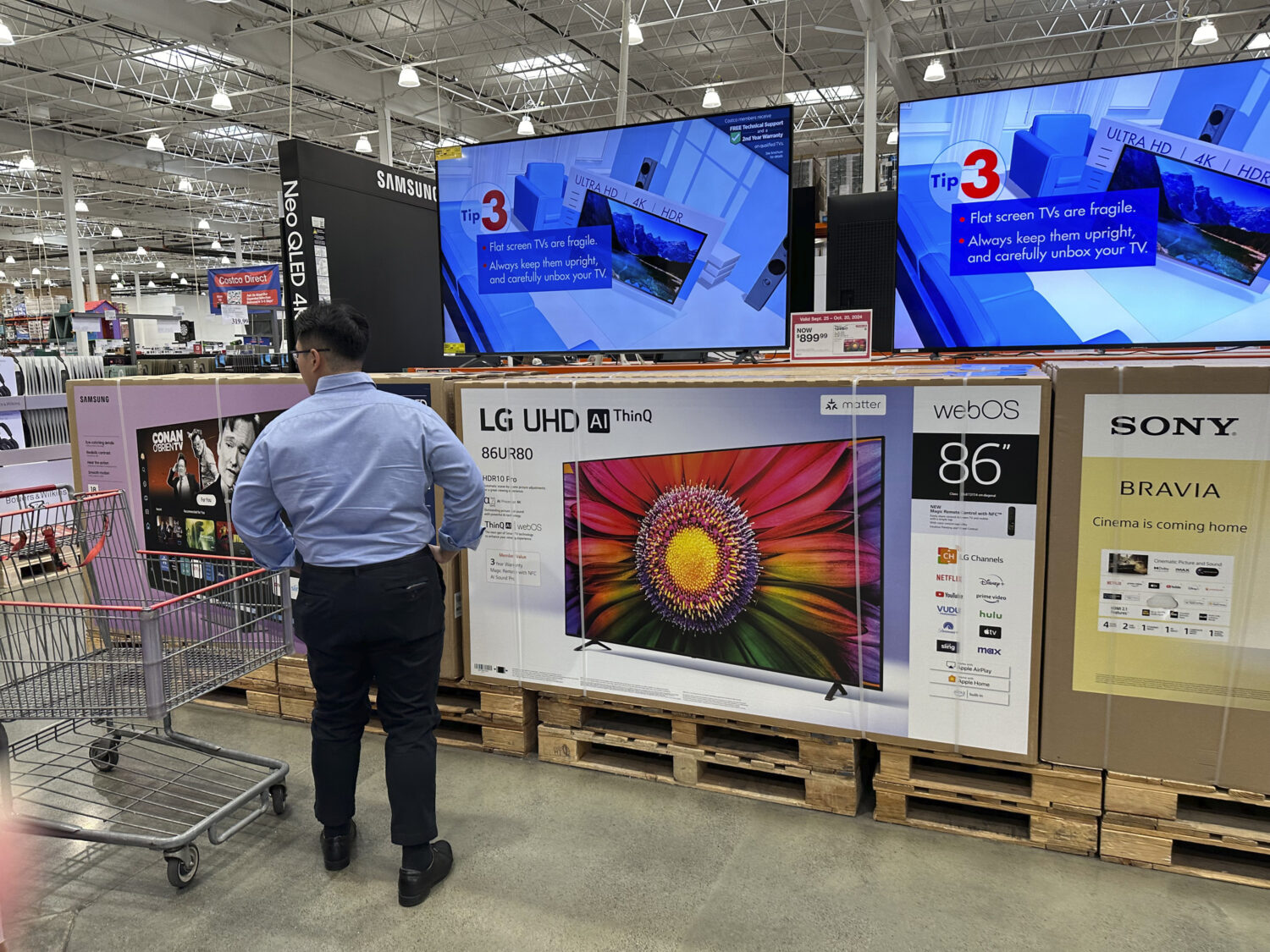 FILE - A shopper considers large-screen televisions on display in a Costco warehouse Oct. 3, 2024, ...
