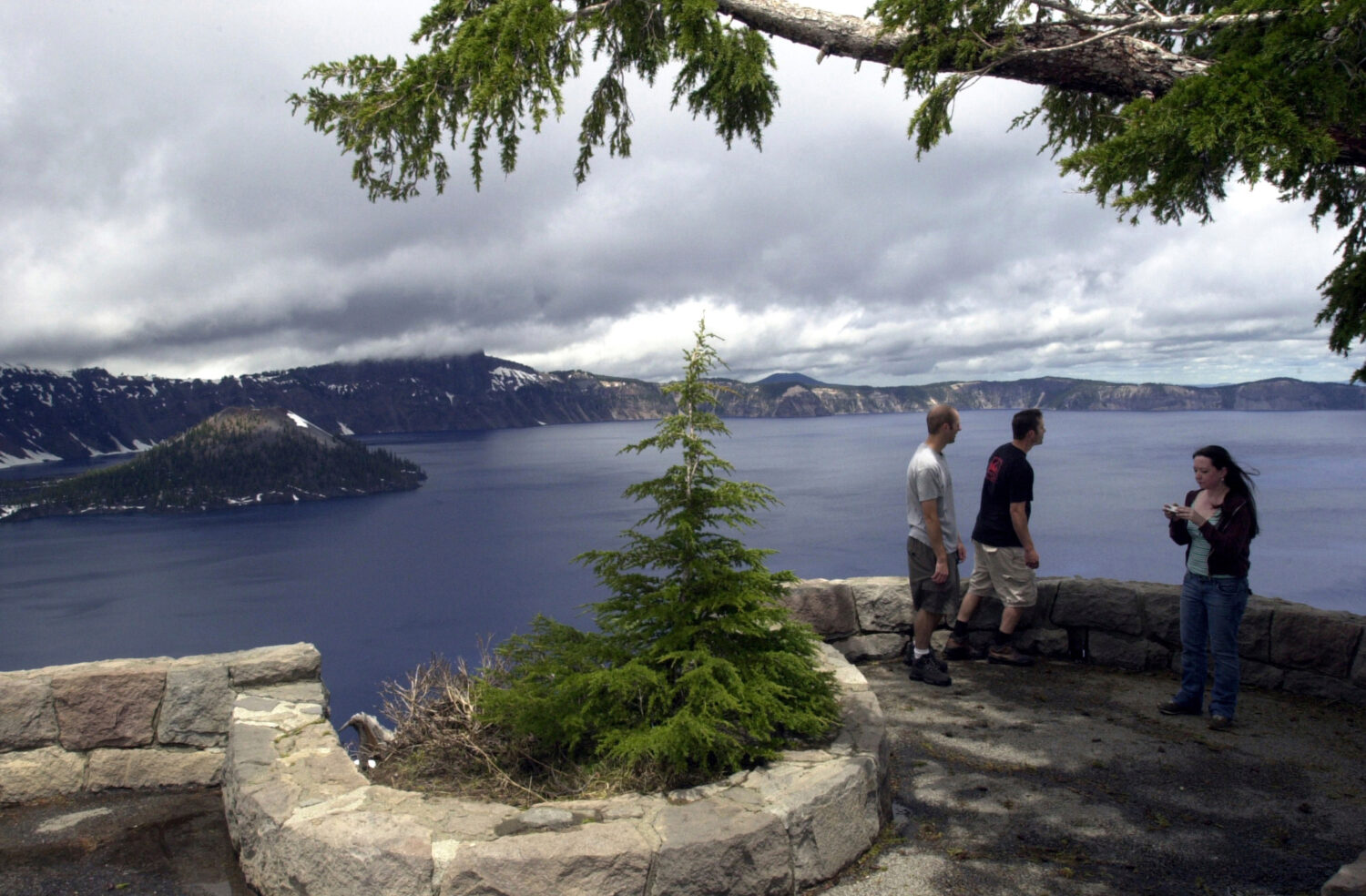 FILE - In this June 16, 2006, tourists take in the view at Crater Lake National Park, Ore. (AP Phot...