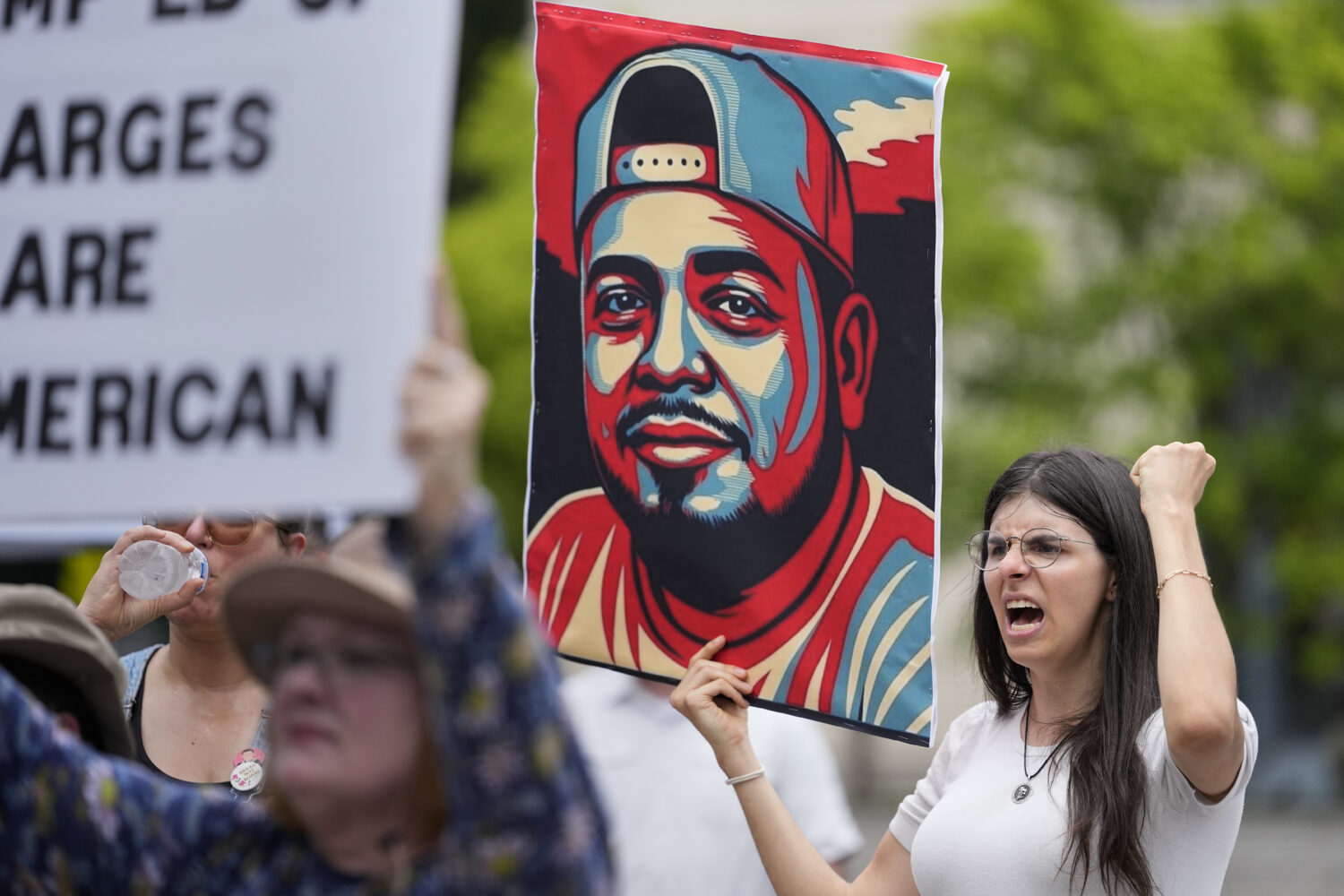 Brianna O'Keefe yells as she holds a portrait of Kilmar Obrego Garcia during a protest outside the ...