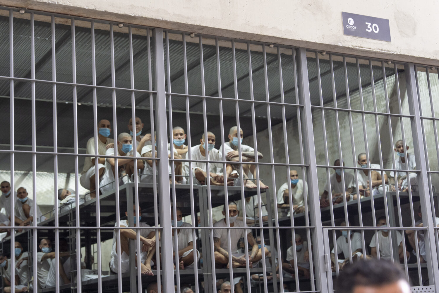 FILE - Prisoners look out of their cell as Homeland Security Secretary Kristi Noem tours the Terror...