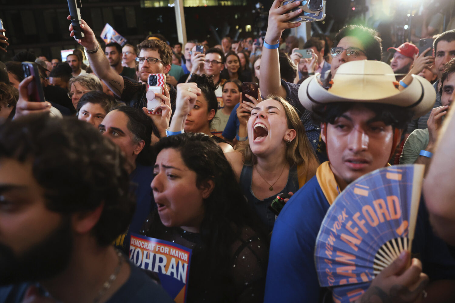 Supporters of Democratic mayoral candidate Zohran Mamdani cheer while he speaks at his primary elec...