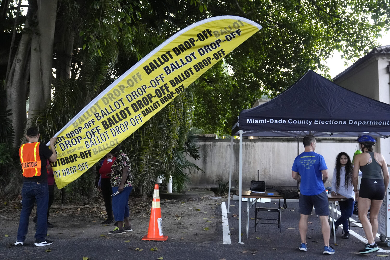 FILE - A poll worker puts up a sign for a ballot drop off location on the first day of early voting...