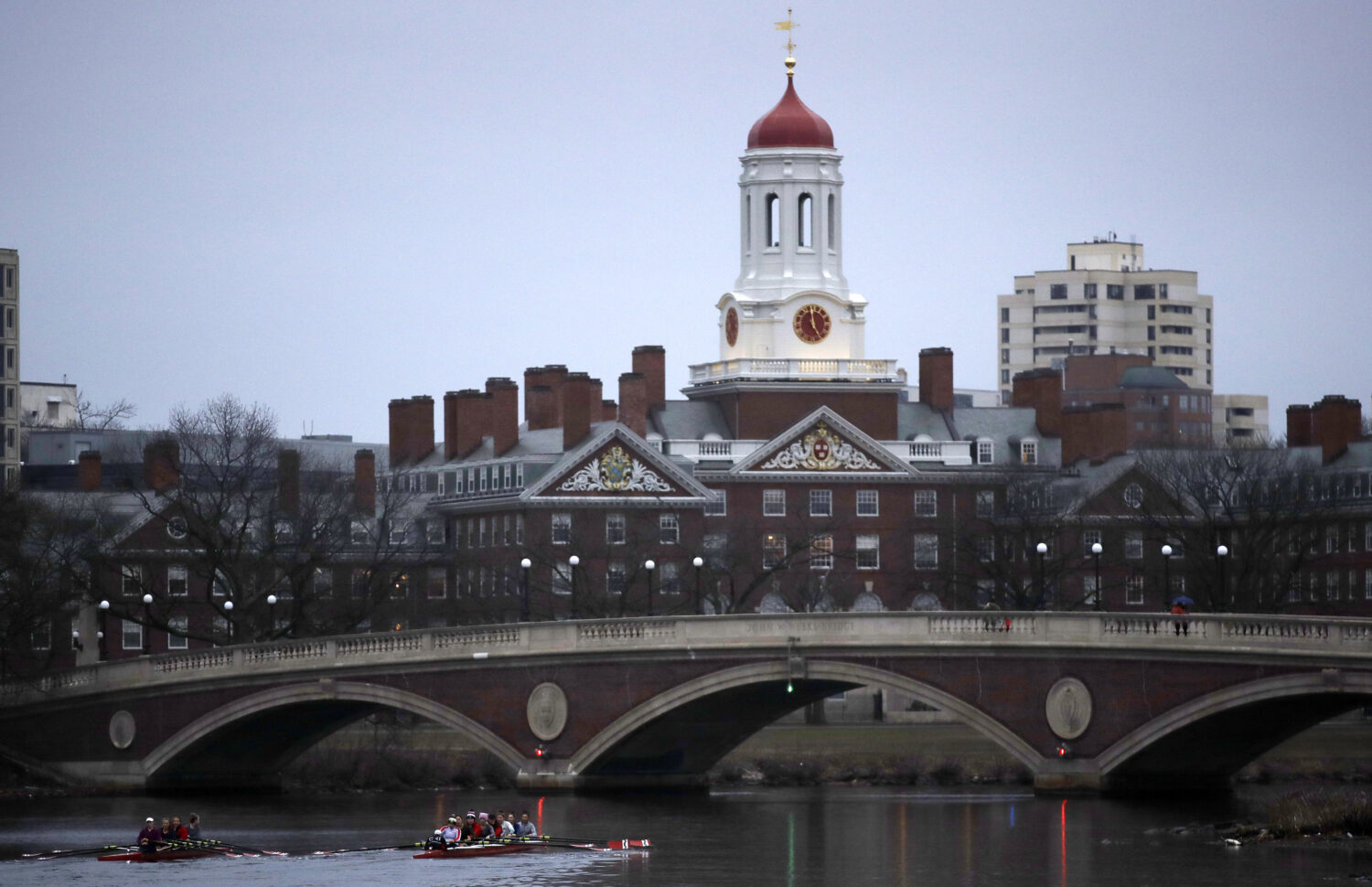 FILE - Rowers paddle down the Charles River near the campus of Harvard University in Cambridge, Mas...