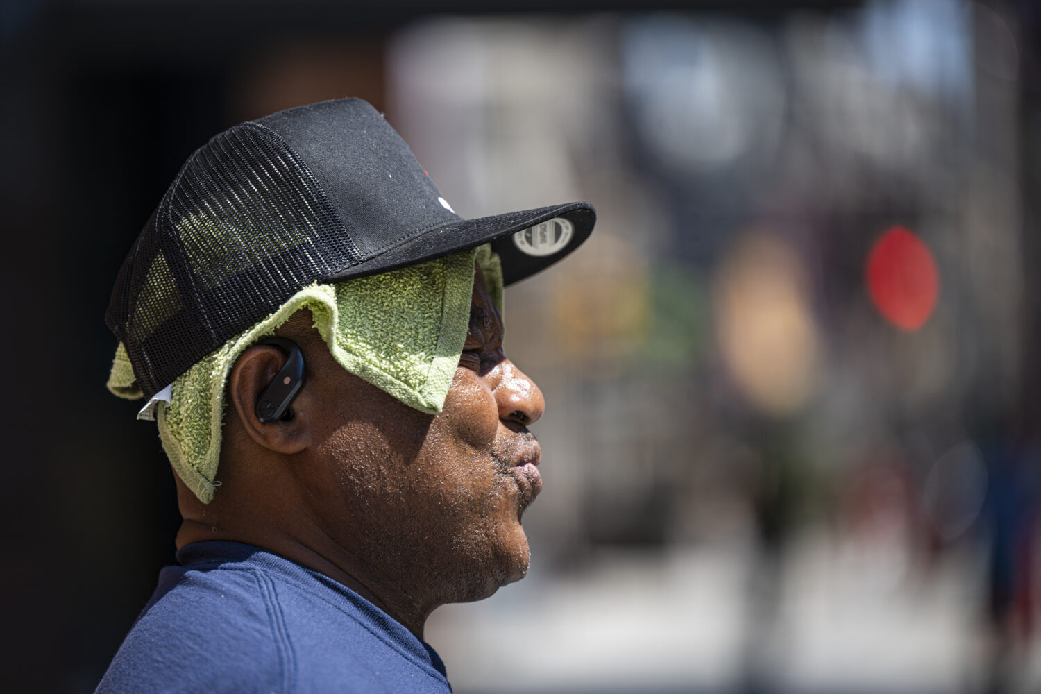 Dwayne Chapaman wears a wet cloth on his head to combat the heat while crossing Broad Street in Phi...