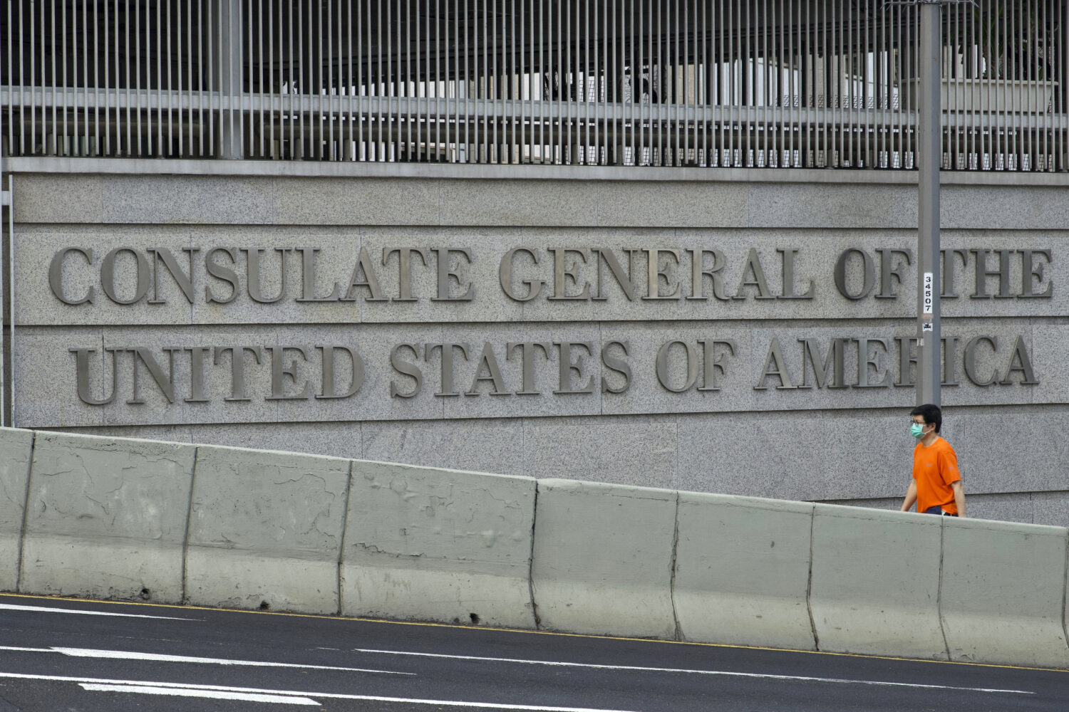 FILE - A man walks past U.S. Consulate in Hong Kong, March 15, 2021. (AP Photo/Vincent Yu, File)Cre...