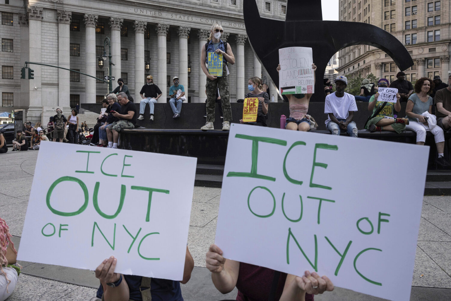 Demonstrators hold signs and chant during a protest against deportation by Immigration and Customs ...