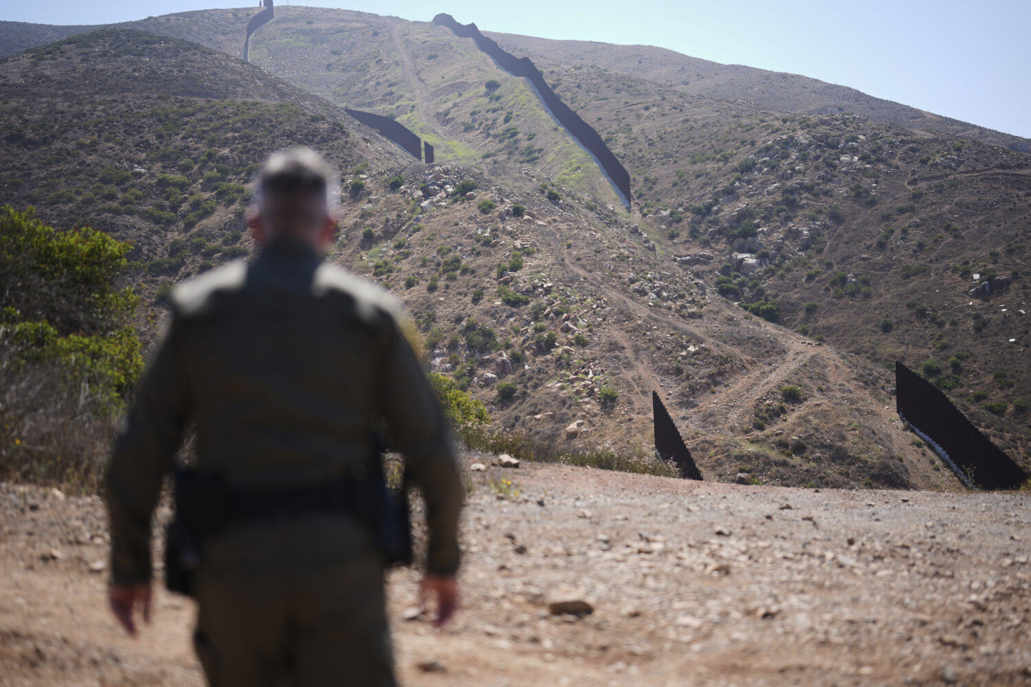 Border Patrol Agent Rood looks out to a gap in the two border walls separating Mexico and the Unite...