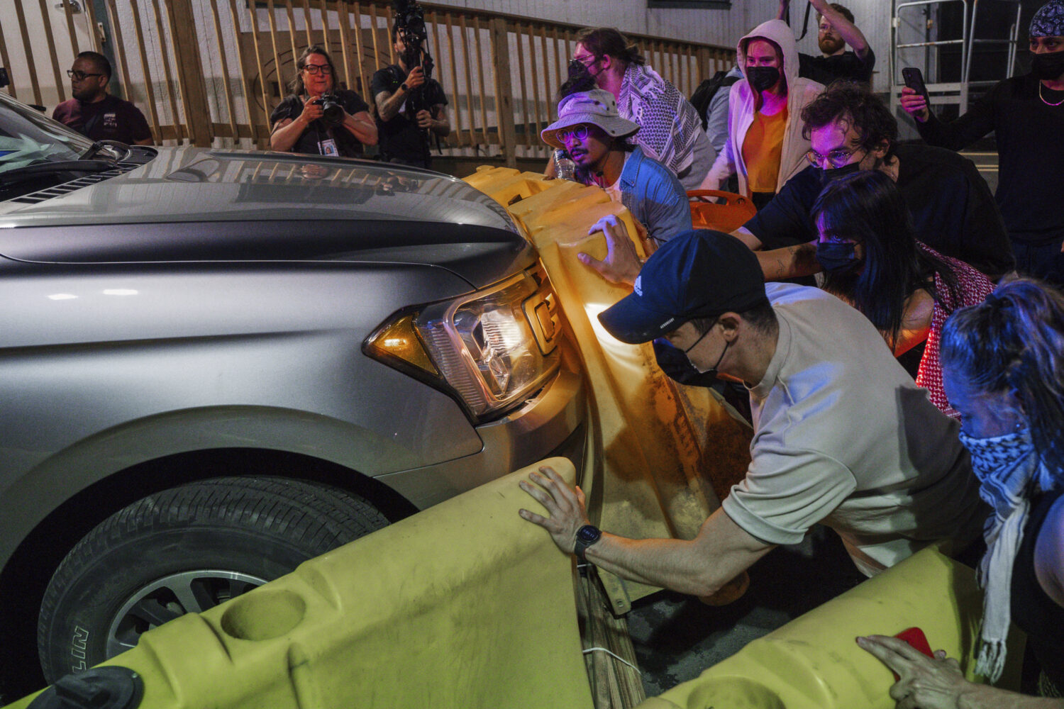 Protesters attempt to block a vehicle from leaving the Delaney Hall Detention Facility during prote...
