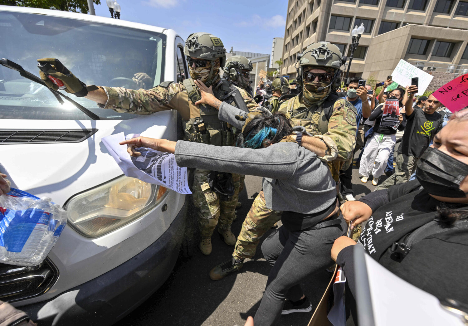 Police use pepper spray as they move protesters away from a van leaving the Federal Building in San...