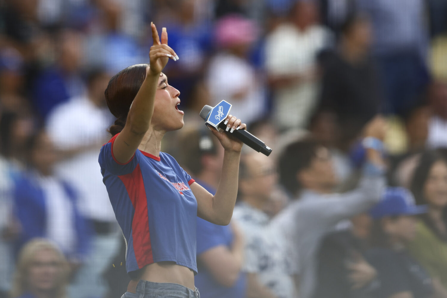 FILE - Music artist Nezza sings the national anthem prior to a baseball game between the Los Angele...